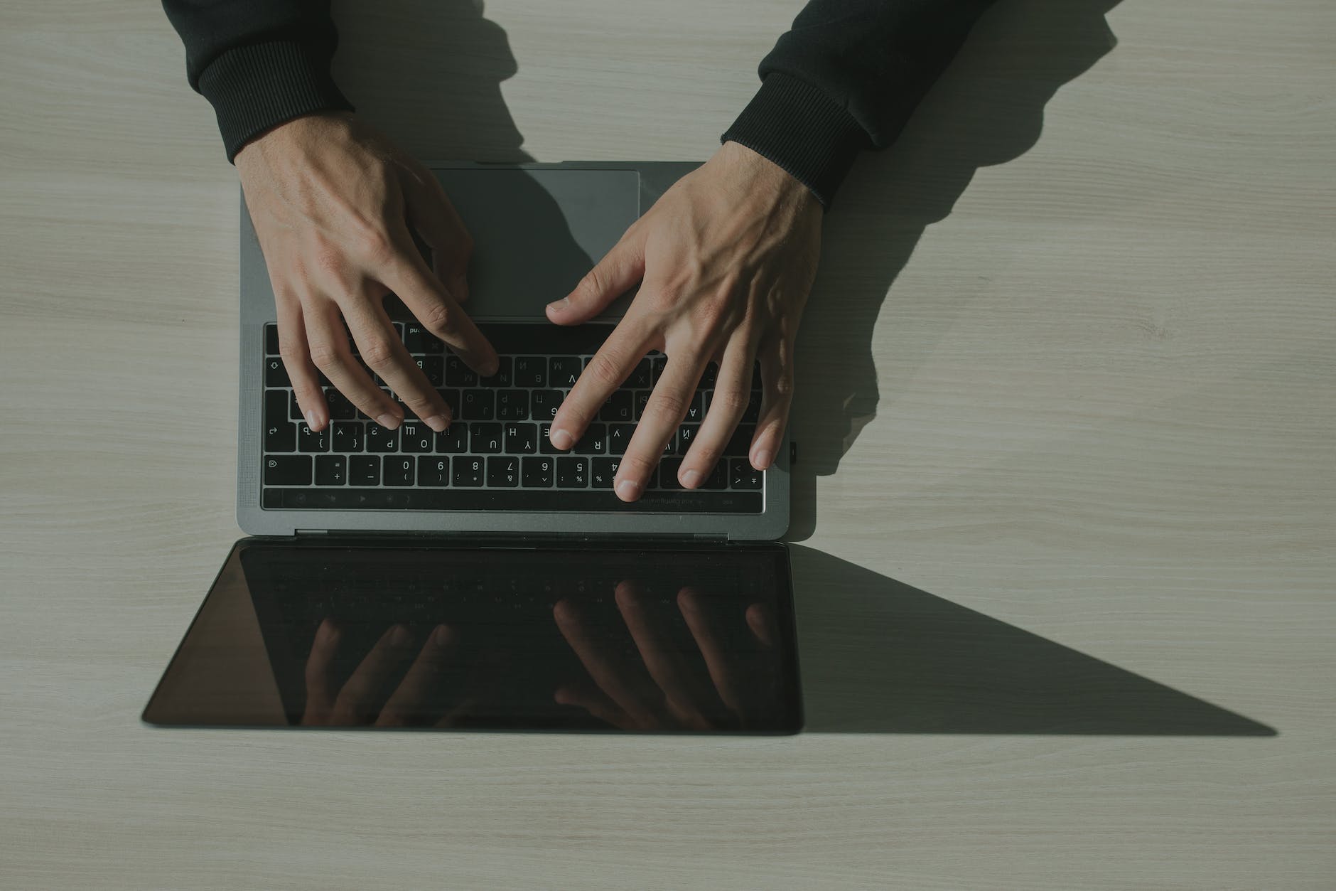 hands typing on a laptop keyboard